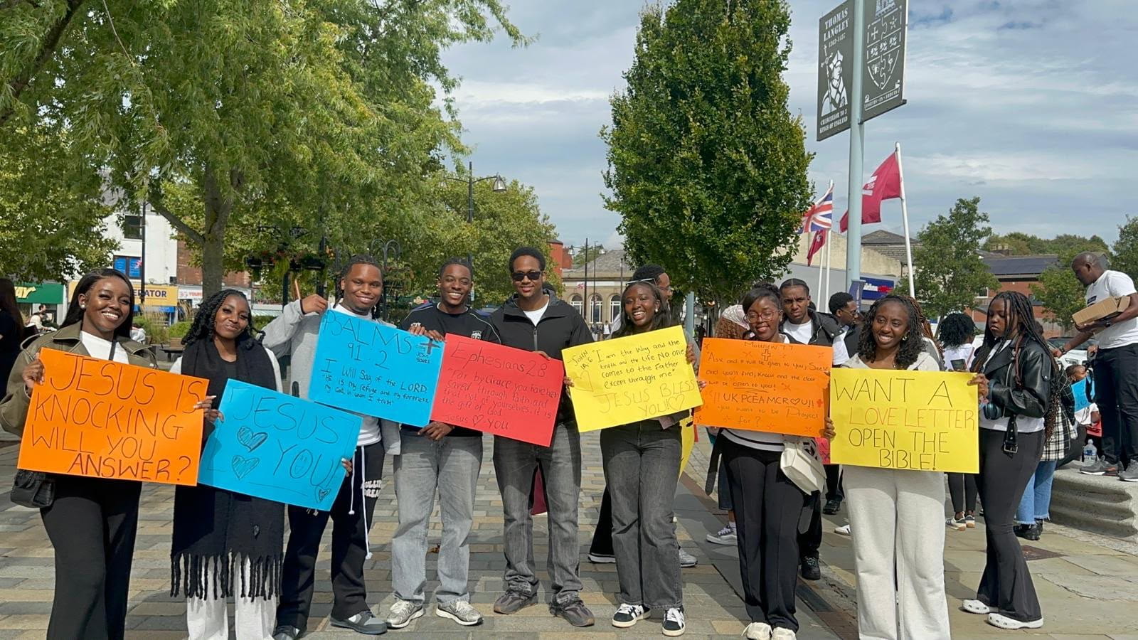 UK PCEA youth standing together with evangelism signs during a past outreach event